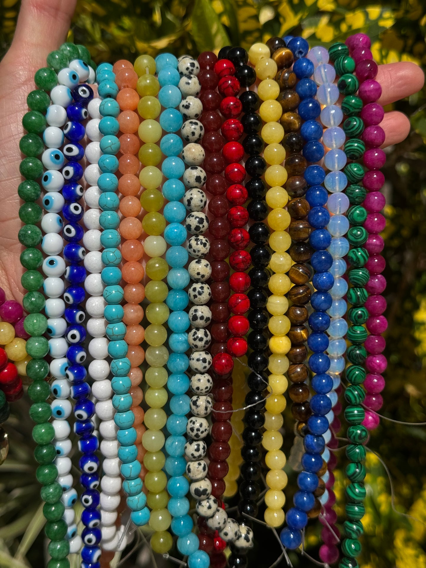 Stack of colorful beaded bracelets with a blurred natural background