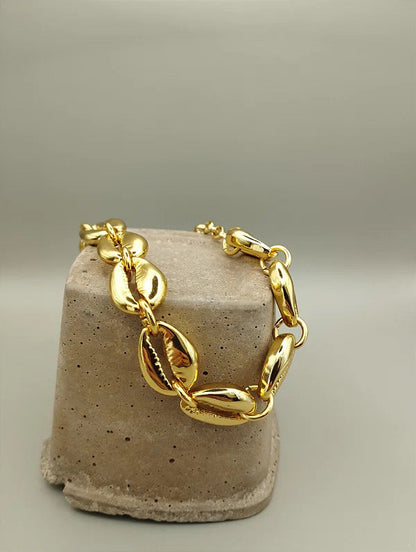 Gold cowrie shell jewelry styled for summer