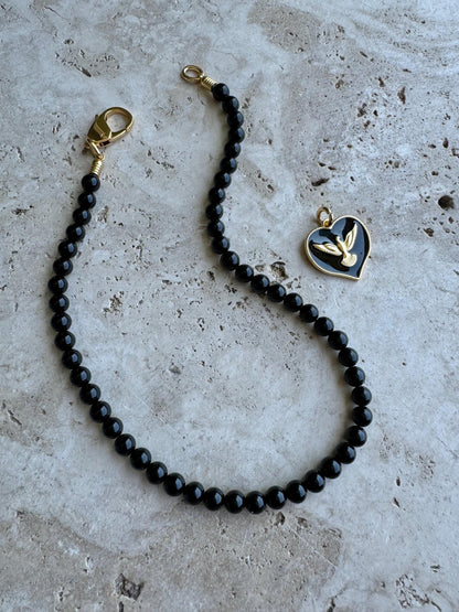 Black obsidian beaded necklace with cross charm and gold chain options — handmade in Florida by AVINZIA
