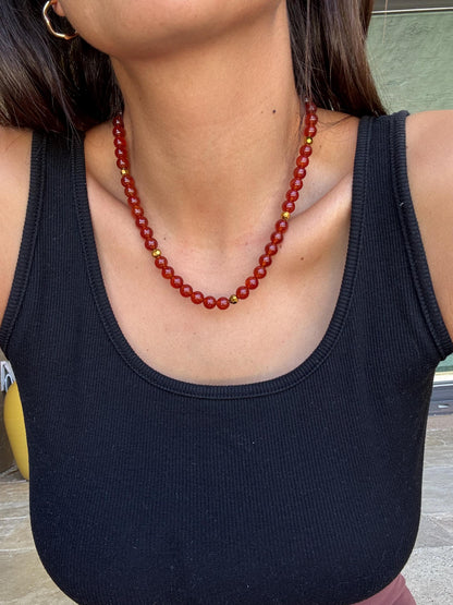 Carnelian beaded gemstone necklace with gold tooth charm by AVINZIA — handmade coastal jewelry